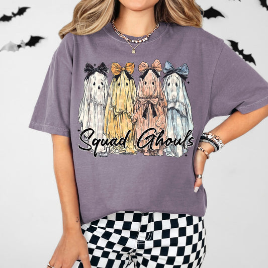 Person wearing a purple t-shirt with ghost illustrations and 'Squad Ghouls' text on a white background.