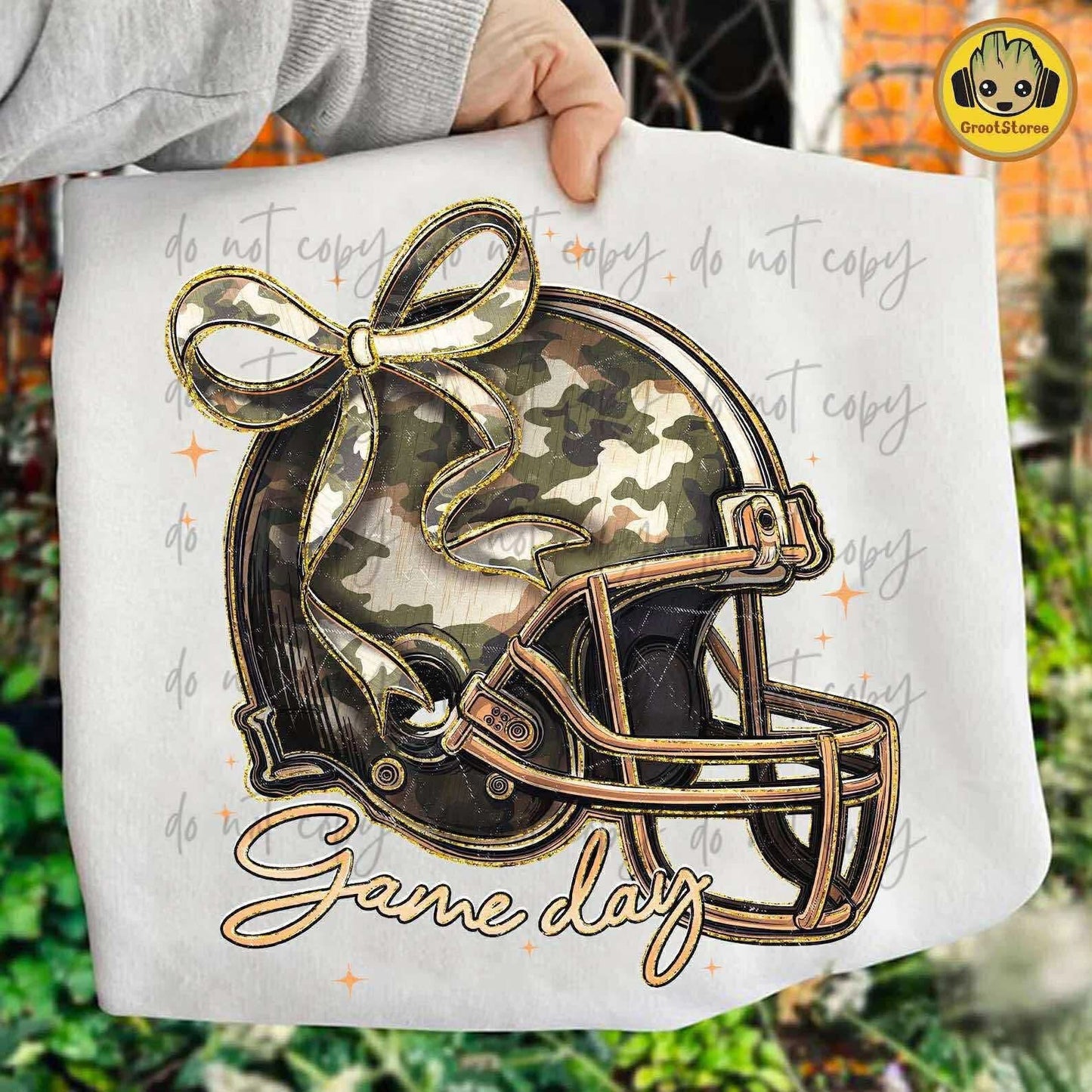 T-shirt  with camouflage football helmet and bow design, text 'Game Day' on a white background.